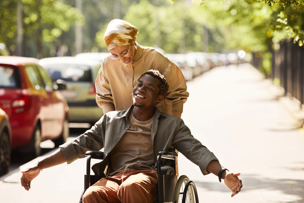 women walking with a disabled men on wheelchair